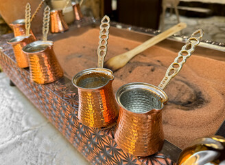 Traditional Turkish coffee in copper turks with long handles on tray with sand. Real coffee...
