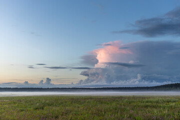 A large cloud in the sky is visible over a field