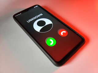 A phone that is receiving a call from an unknown contact who is a scammer. All this is on a white background with a red glow