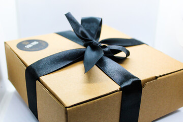 selective focus isolated on white, brown gift box or hamper box with black ribbon ornament for a gift for a loved one