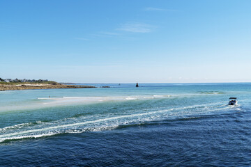 Un cama&iuml;eu de bleu se d&eacute;ploie sur l'oc&eacute;an Atlantique &agrave; Audierne, o&ugrave; le sillage d'un bateau refl&egrave;te le calme d'une parfaite journ&eacute;e d'&eacute;t&eacute;.