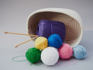 Cozy homely atmosphere. Female hobby knitting and Crochet. Yarn multicolor in a basket. Skeins and...