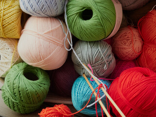 Cozy homely atmosphere. Female hobby knitting and Crochet. Yarn multicolor in a basket. Skeins and...