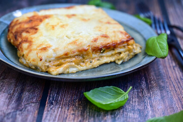  Italian Lasagna bolognese  covered with parmesan cheese  on awooden  background.