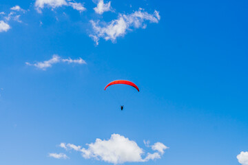 View of the sky. Person flying in a paraglider, leisure activity. Travel and landscapes.
