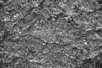 Processed collage of shiny metal silver gray foil crumpled packaging material texture
