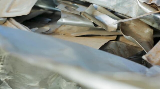 Panning shot of crumpled metal sheets in a scrapyard