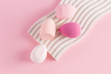 Four beauty blenders sponges in pink shades on a white embossed catwalk and a pink background. top view. Care and beauty concept. Makeup tool.