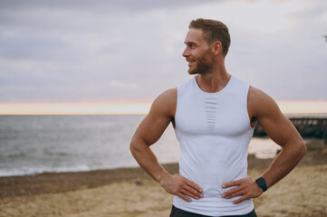 Young strong sporty athletic toned fit sportsman man he wear sports clothes stand akimbo look aside...