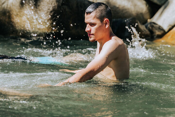 Obraz premium Latin man with beard happy in the water in a river in Colombia. Waterfalls and travel. People smiling.