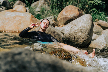 Latin woman enjoying her vacation on the river. People smiling. Colombian waterfalls, water and travel.