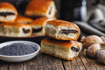 Sweet bun with poppy seed on wooden table.