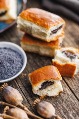 Sweet bun with poppy seed on wooden table.
