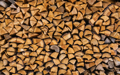 Wooden stumps, firewood stacked in stacks. Stacked split logs. Pile of logs prepared for winter.  High quality photo. Background, photo background