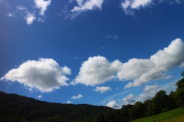 Blue sky and cloud with green mountain.