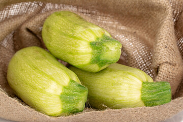 Three ripe zucchini in a jute bag, macro.