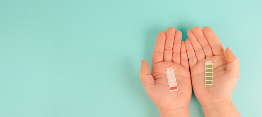 Hand with an empty and a full battery, exhausted by stress against healthy positive lifestyle, work life balance, burnout, low energy 