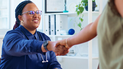 Friendly Female Doctor Shaking Hands with Patient in Medical Office, Establishing Trust and Professional Connection
