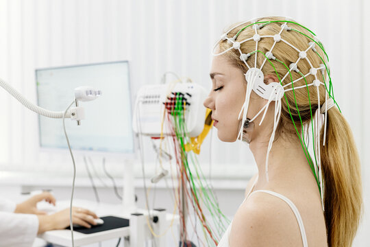 A young woman undergoes an EEG test in a modern clinic, showcasing advanced medical technology and patient care. Ideal for highlighting modern diagnostic procedures and healthcare innovations.