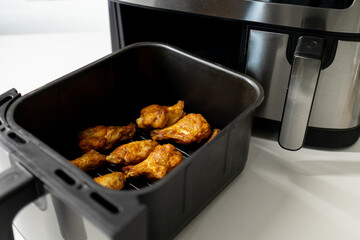 Close-up of chicken wings cooked in an air fryer in the kitchen. Juicy Chicken Wings