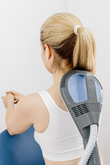 A physiotherapist administers advanced electromagnetic therapy for back pain relief using...