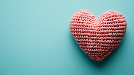 Obraz premium Adorable Knitted Toy Heart on Light Blue Background with Copy Space for Valentine's Day Concepts