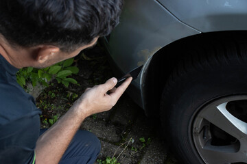 Еuropean man repairing a car. Puttying scratches on paint. Service at a service station....