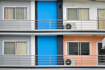 A row of apartment buildings with blue and orange walls. The blue wall is on the left side of the building and the orange wall is on the right side