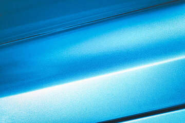A blue car with a shiny paint job. The car is parked in a parking lot