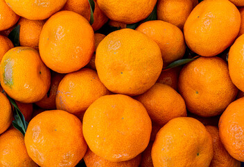 orange mandarin background of fresh juicy tangerines close up, vegan friut conception of citrus