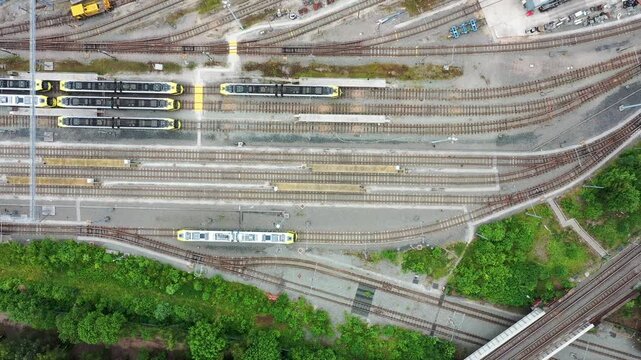Straight down aerial drone footage of the city of Manchester in the UK showing a large selection of train tracks from above in the city area known as Cheetham Hill in the summer time