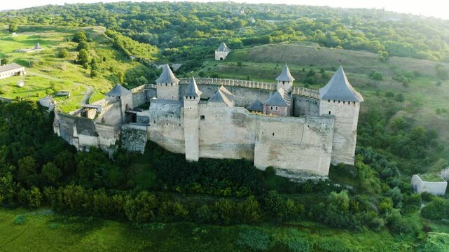 Khotyn Fortress (Ukrainian: Хотинська фортеця; Romanian: Cetatea Hotinului)  fortress of the 10th-18th centuries, huge walls towers on the banks  Dniester,  drone flies by at dawn aerial photography