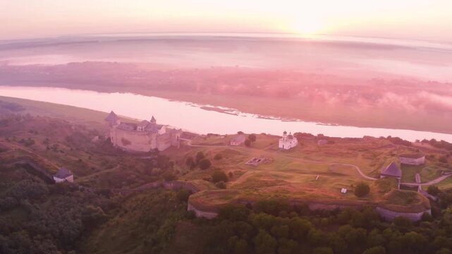 Khotyn Fortress (Ukrainian: Хотинська фортеця; Romanian: Cetatea Hotinului)  fortress of the 10th-18th centuries, huge walls towers on the banks  Dniester,  drone flies by at dawn aerial photography