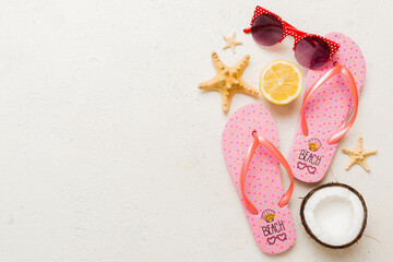 Top view composition of flip flops placed with beach accessories top view on table background....
