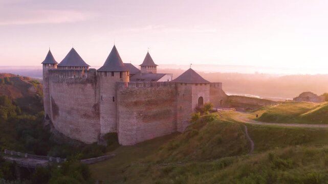 Khotyn Fortress (Ukrainian: Хотинська фортеця; Romanian: Cetatea Hotinului)  fortress of the 10th-18th centuries, huge walls towers on the banks  Dniester,  drone flies by at dawn aerial photography