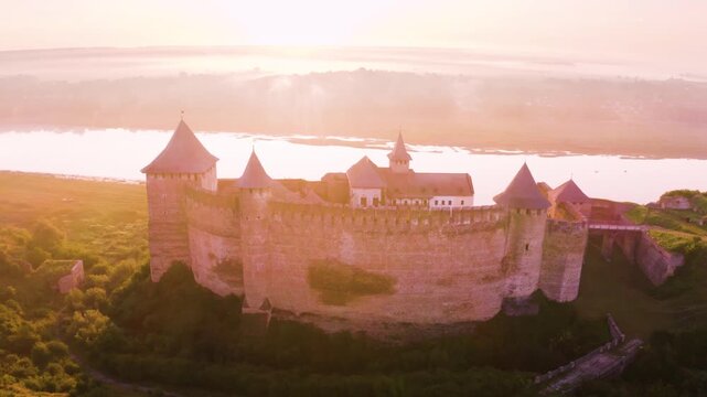 Khotyn Fortress (Ukrainian: Хотинська фортеця; Romanian: Cetatea Hotinului)  fortress of the 10th-18th centuries, huge walls towers on the banks  Dniester,  drone flies by at dawn aerial photography