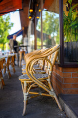 Row of chairs on the sidewalk in front of a café.