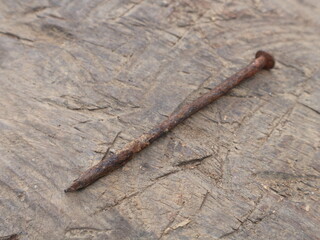 A rusty old rusty nail on a wooden surface