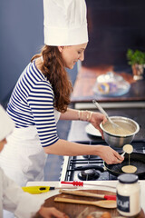 Woman, chef and happy with baking on stove in kitchen at home for catering service and hospitality. Female person, career and talent with smile for fun, enjoy and profession or skill with confidence