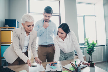 Fototapeta premium Photo of two employees mature boss woman discuss documents office team meeting professional collaborate work together in modern workplace