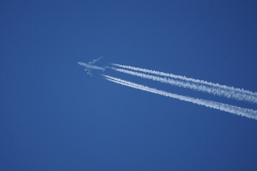 Passagierflugzeug fliegt vor Blauen Himmel Kondensstreifen Chemtrail