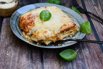  Italian Lasagna bolognese  covered with parmesan cheese  on awooden  background.