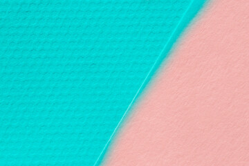 close up of light red and turquoise sheets of cardboard