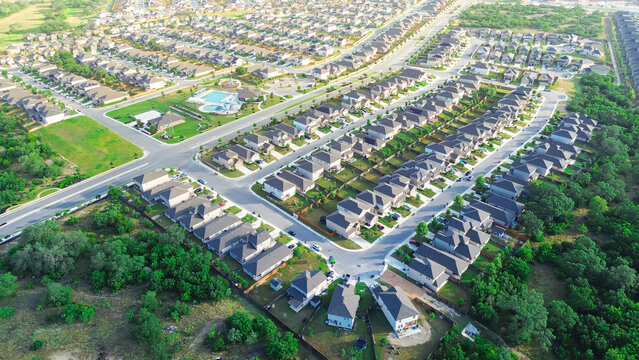 New construction homes in master planned community West of San Antonio, Texas, suburban two-story houses in long narrow lot in homeowner associations with swimming pool, intersection, aerial view