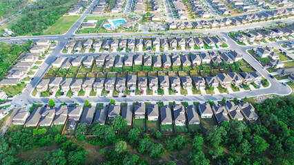 Suburban houses share backyard fence boundary between two properties in new construction homes neighborhood West of San Antonio, Texas, cul-de-sac keyhole shape dead-end streets, aerial view