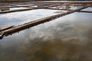 Fototapeta premium Salt pans surface with reflections of the sky at Pomorie near the lake, Burgas Province, Bulgarian Black Sea coast