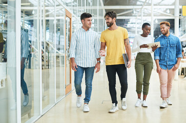 Obraz premium Walking, diversity and employees in modern office, tech and digital app with connection. Group, graphic designers or business people with tablet, smartphone and conversation with network and internet