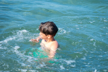 young boy play in open water, ocean on sunny summer day, Water activities, prevent drowning, aquatic adventures foster curiosity and love for environment in kids