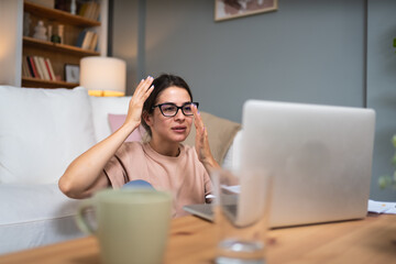 Young nervous sick frustrated woman working at home office on laptop computer, migraine head pain...