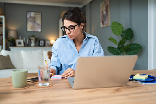 Business woman video call preparation. Young female businessperson prepare herself for online meeting, making notes for internet presentation, thinking and planning for better achievement with client. - Powered by Adobe
